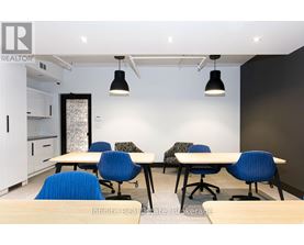 A conference room with a long table and chairs.