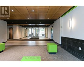 A hallway with a green cube on the floor and a sign that says Infinite Real Estate Brokerage.