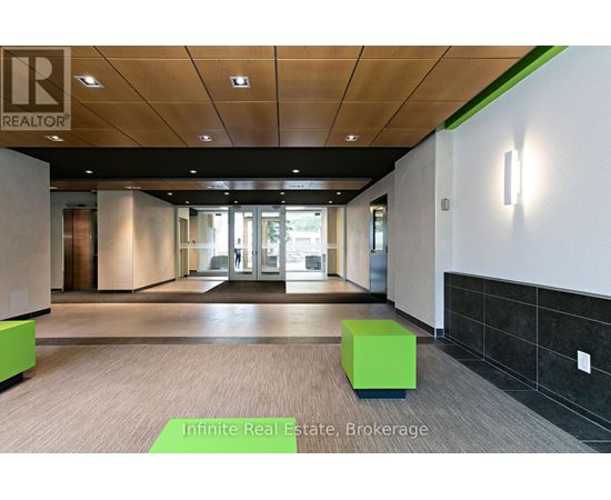 A hallway with a green cube on the floor and a sign that says Infinite Real Estate Brokerage.