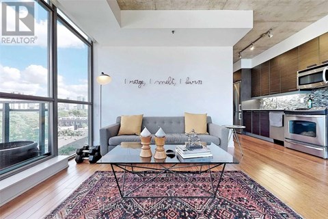 A living room with a grey couch and a coffee table in front of a window.