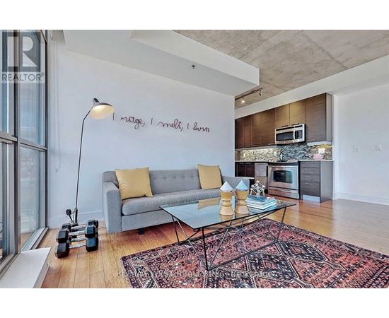 A living room with a grey couch, a coffee table, and a rug.