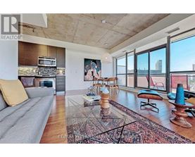 A living room with a grey sofa and a rug in the middle.