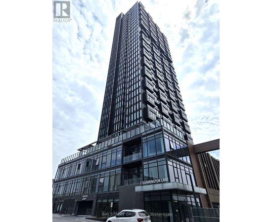A tall building with a glass facade and a sign that reads "5 Quarington Lane".