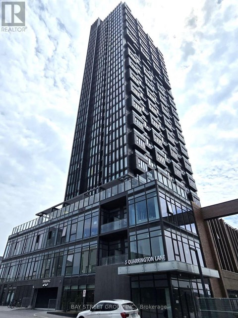 A tall building with a glass facade and a sign that reads "5 Quarington Lane".