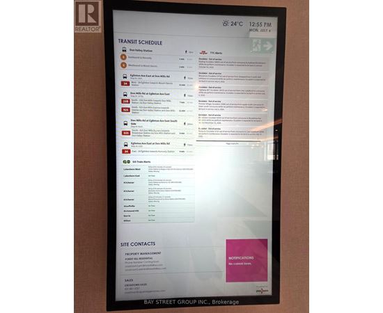 A monitor displays a transit schedule with bus numbers and destinations.