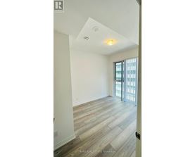 A room with a slanted ceiling and a door leading to a balcony.
