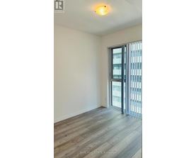 A room with a sliding glass door leading to a balcony.