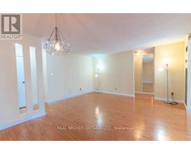 A large empty room with wooden floors and a chandelier.