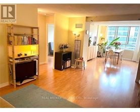 A living room with a television and a dining area.