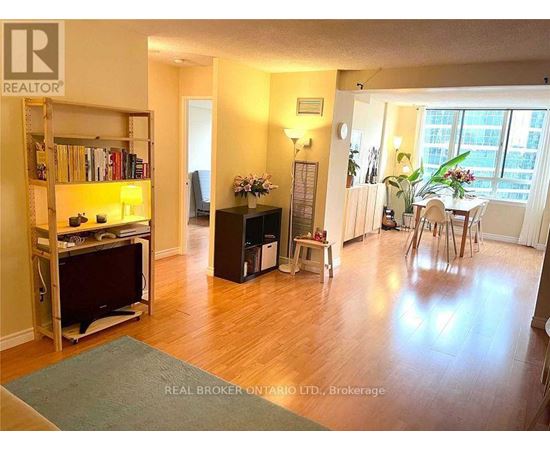 A living room with a television and a dining area.