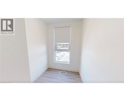 A room with a window showing a view of a building.