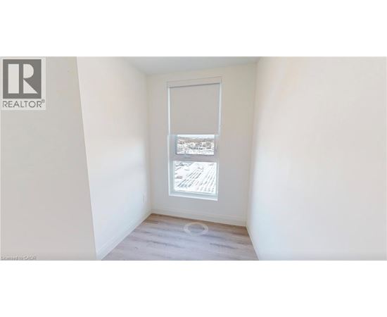 A room with a window showing a view of a building.