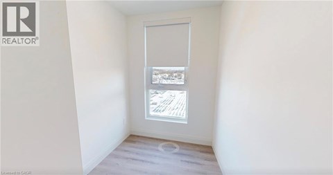 A room with a window showing a view of a building.