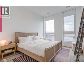 A bedroom with a large bed and a window overlooking a parking lot.