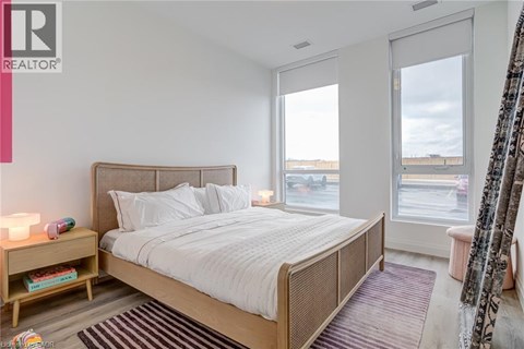 A bedroom with a large bed and a window overlooking a parking lot.