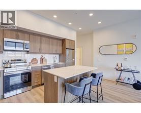 A modern kitchen with a large island and chairs.