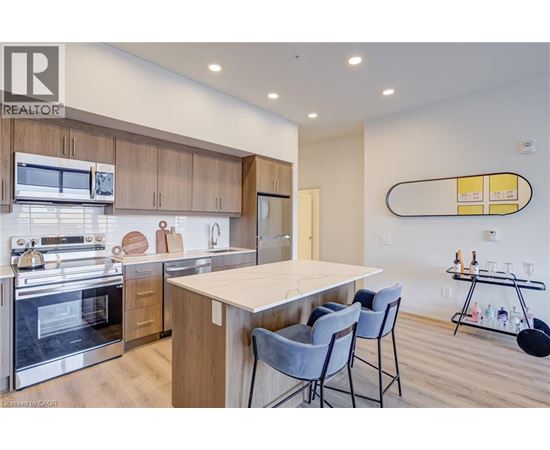A modern kitchen with a large island and chairs.