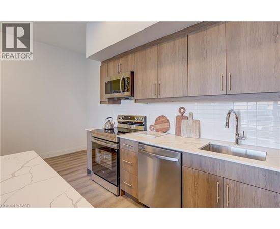 A modern kitchen with wooden cabinets and stainless steel appliances.