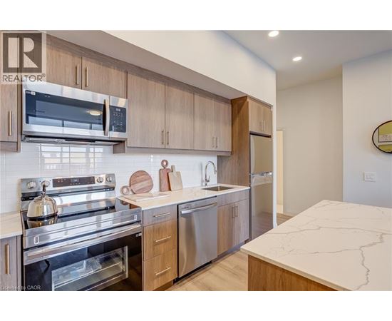 A modern kitchen with wooden cabinets and stainless steel appliances.