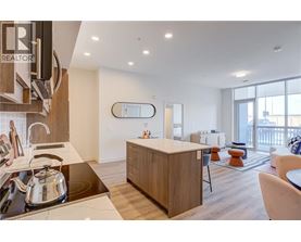 A modern kitchen with a large island and a dining area.