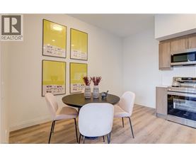 A dining room with a table and chairs and a fridge in the corner.