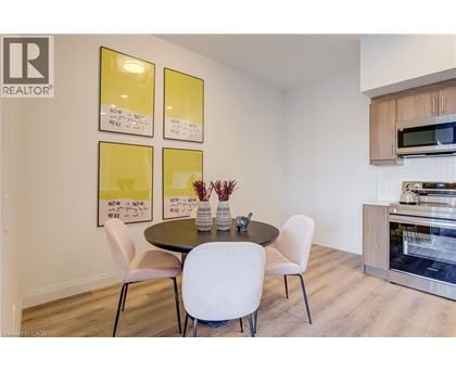 A dining room with a table and chairs and a fridge in the corner.