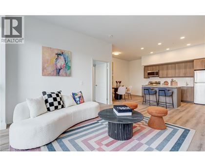 A living room with a white couch and a painting on the wall.