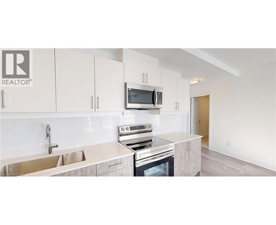 A modern kitchen with white cabinets and a stainless steel oven.