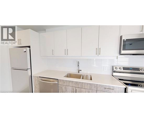 A kitchen with white cabinets and a white fridge.