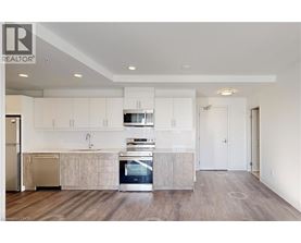 A modern kitchen with white cabinets and a wooden floor.