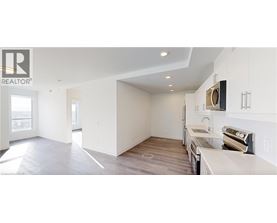 A spacious kitchen with white cabinets and a flat screen TV mounted above the counter.
