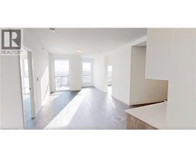 A spacious, empty room with a large window and a door leading to another room.