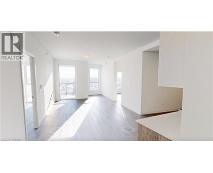 A spacious, empty room with a large window and a door leading to another room.