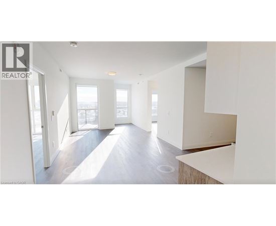 A spacious, empty room with a large window and a door leading to another room.