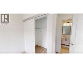 A bedroom with a white door and a white wall.