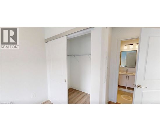 A bedroom with a white door and a white wall.