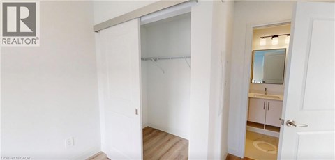 A bedroom with a white door and a white wall.