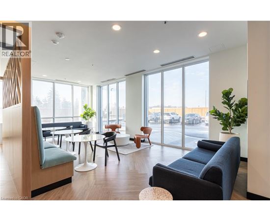 A living room with a blue couch and a wooden chair.