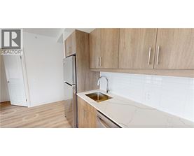A kitchen with a sink and a refrigerator.