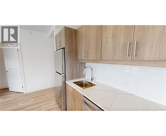 A kitchen with a sink and a refrigerator.
