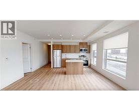 A modern kitchen with wooden floors and white walls.