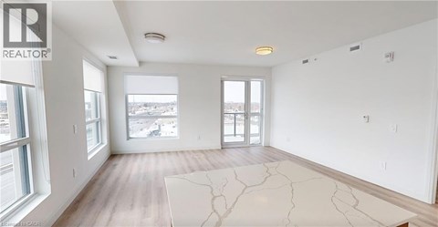 A spacious, empty room with a large window overlooking a cityscape.