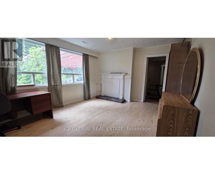 A room with a white cabinet and a window with curtains.
