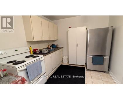 A kitchen with white cabinets and a stove top oven.