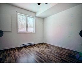 A room with a window and a radiator on the wall.