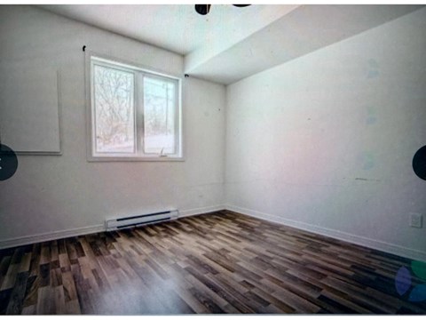 A room with a window and a radiator on the wall.