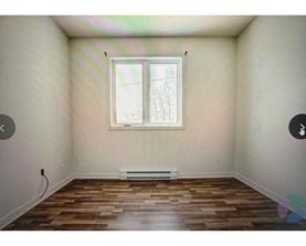 A room with a window and wooden flooring.