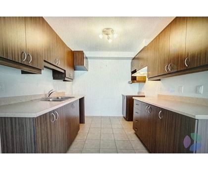 A kitchen with brown cabinets and a white counter top.