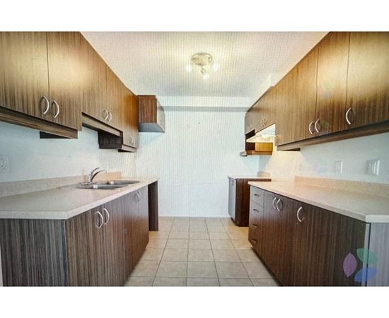 A kitchen with brown cabinets and a white counter top.