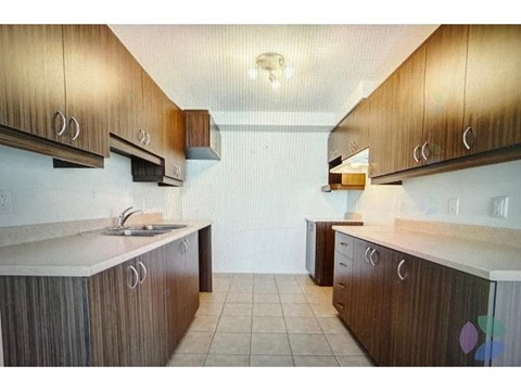 A kitchen with brown cabinets and a white counter top.